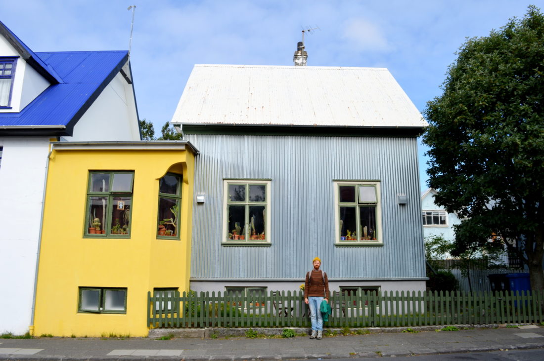 Reykjavik Gay Travel Daan in front of a grey and yellow house | Gay Couple Travel City Weekend Reykjavik Iceland © Coupleofmen.com