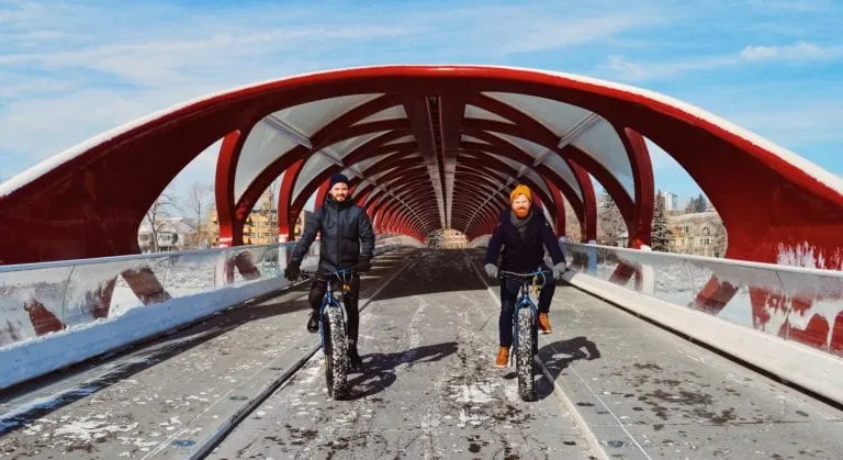 Karl & Daan in front of the red Peace Bridge by Calatrava | Fat Tire Biking Calgary Nomadic Mobile Gear © CoupleofMen.com