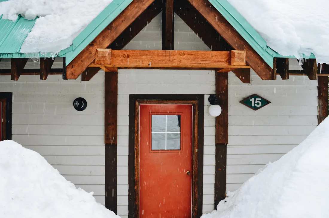 Remarkable red doors & jade-colored roof tops overed with snow | Emerald Lake Lodge gay-friendly © Coupleofmen.com
