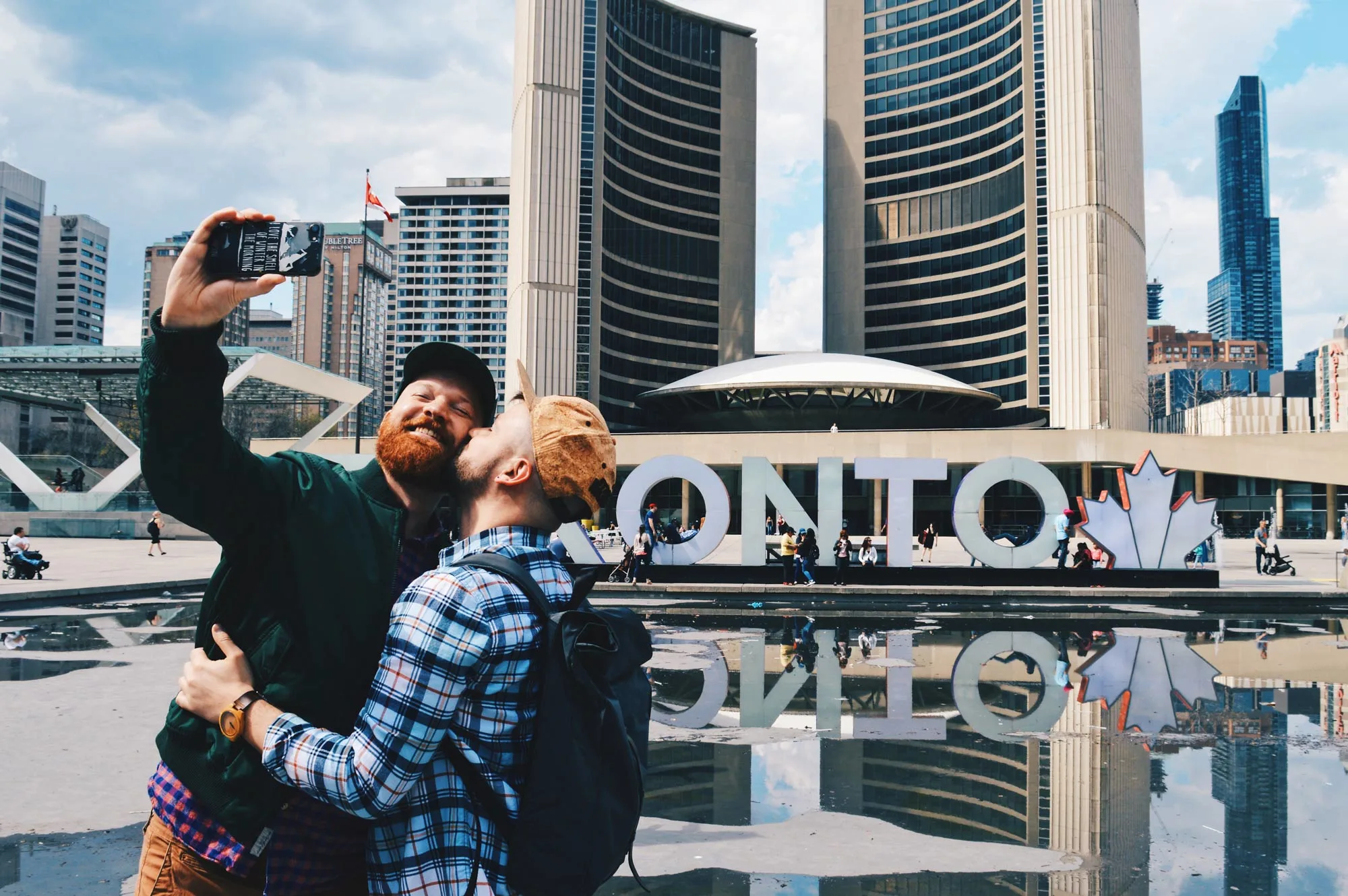 Gay Kiss Selfie infront of the Toronto Sign right next to the Marriott Downtown Toronto Eaton Centre © Coupleofmen.com