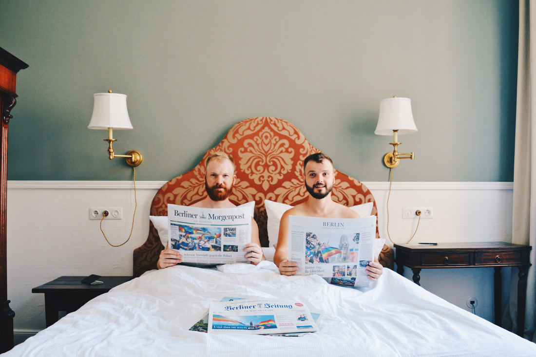 Gay-friendly Hotel Berlin Henri Kurfürstendamm Charlottenburg Gay Couple naked in bed reading Berliner Morgenpost Newspaper about Gay Pride © Coupleofmen