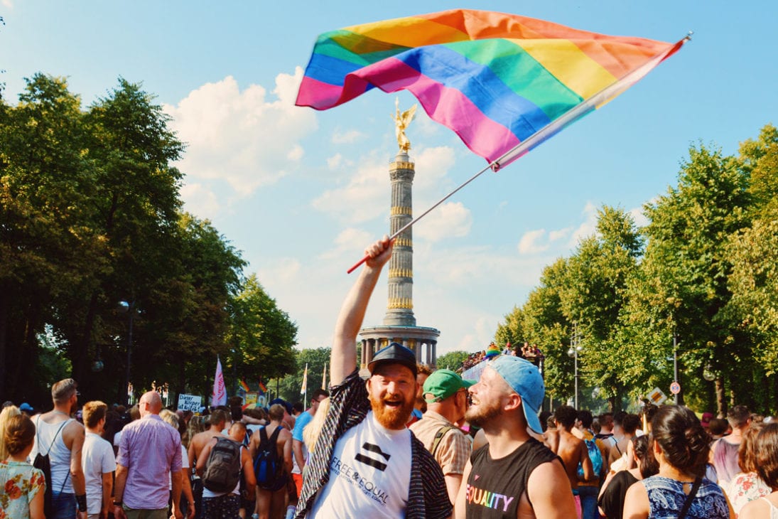 Happy Pride - Couple of Men waving the Rainbow Flag over the Victory Column together | CSD Berlin Gay Pride 2018 © Coupleofmen.com