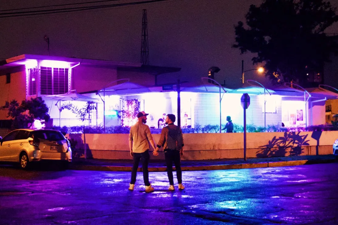 Gay Travel Journal Costa Rica Hand-in-hand in front of the Neon Ice sign, our favorite gay bar in San José | Gay-friendly Costa Rica © Coupleofmen.com