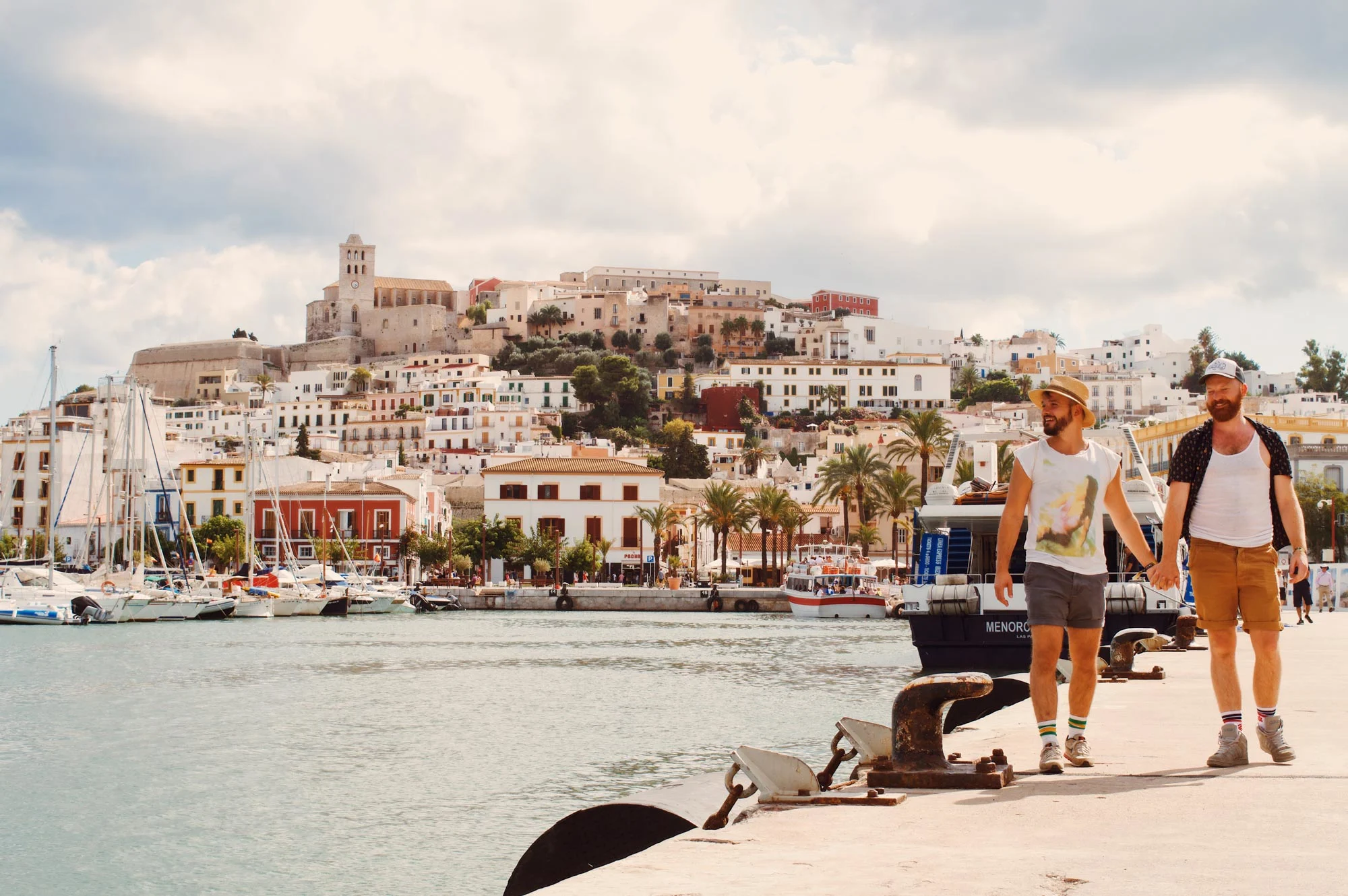 Ibiza Gay Travel Tips Gay Travel Blogger hand in hand at the Gay Beach in Ibiza | Gay Travel Ibiza © Coupleofmen.com