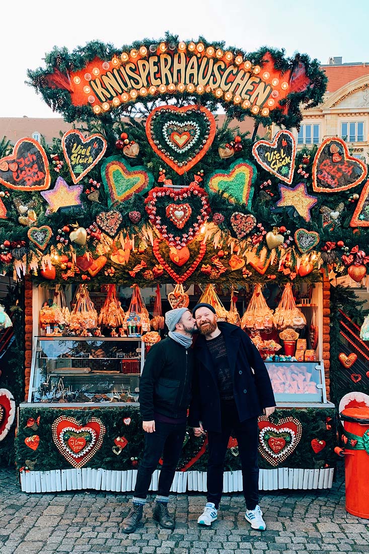 Christmas kiss in front of the gingerbread house at Dresden Striezelmarkt © Coupleofmen.com
