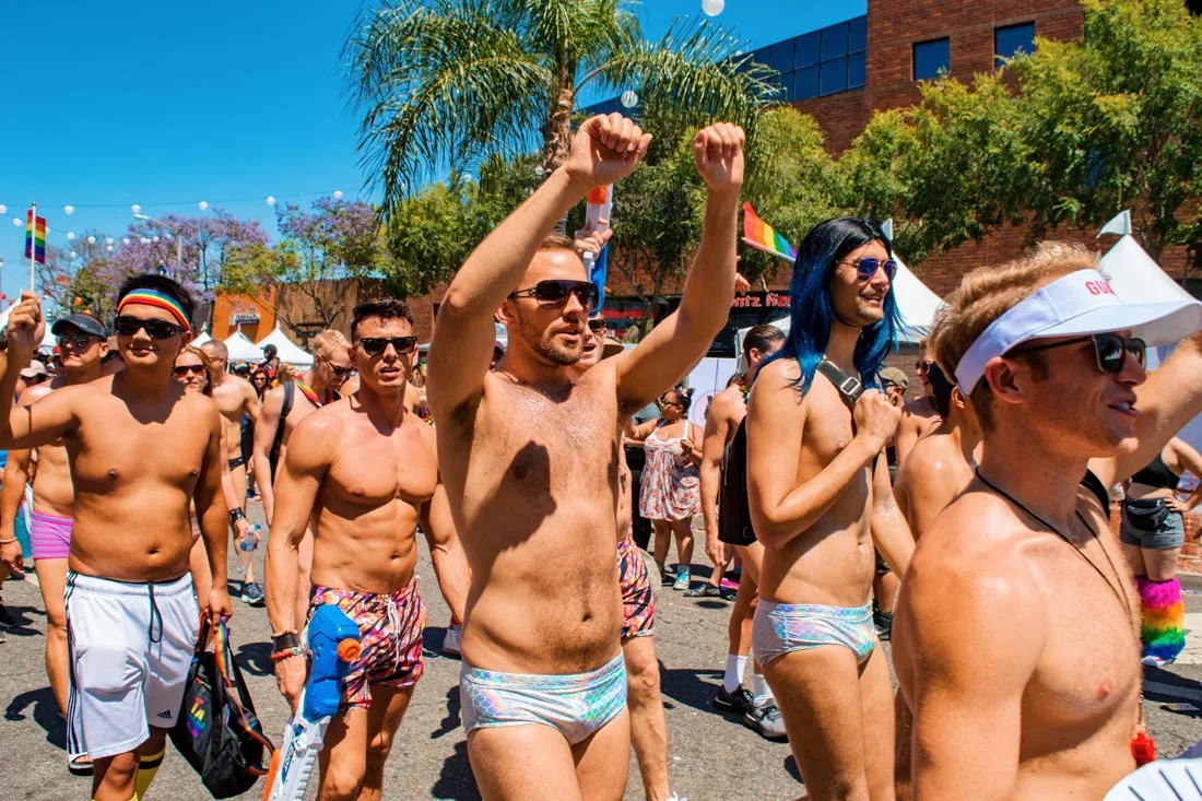 Gay swim team for some extra sexy fun on the streets of Los Angeles California. Half naked guys in swim wear demonstrating and dancing during LA Pride 2019© Coupleofmen.com