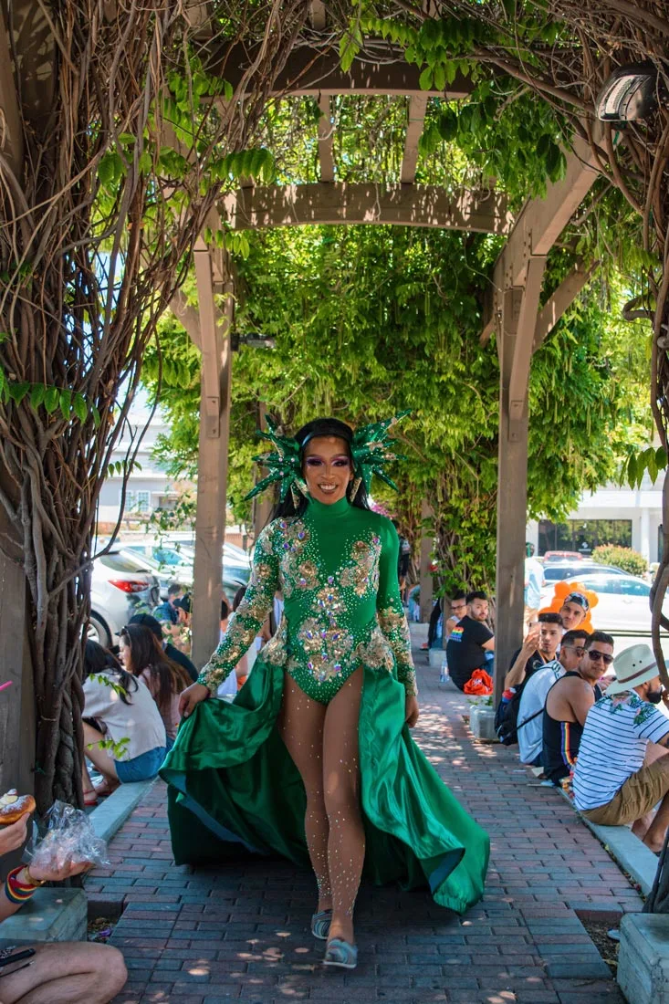 Even during lunch break - Drag Beauty in green dress making a sidewalk to her catwalk © Coupleofmen.com