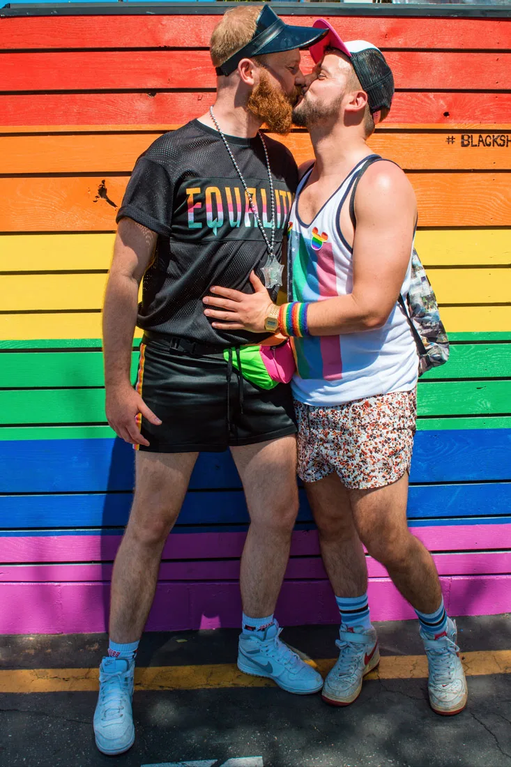 Two bearded men kissing. Gay Travel Blogger: Because it is all about love - The best way to protest during Gay Pride is to give each other a gay kiss in front of a rainbow wall © Coupleofmen.com
