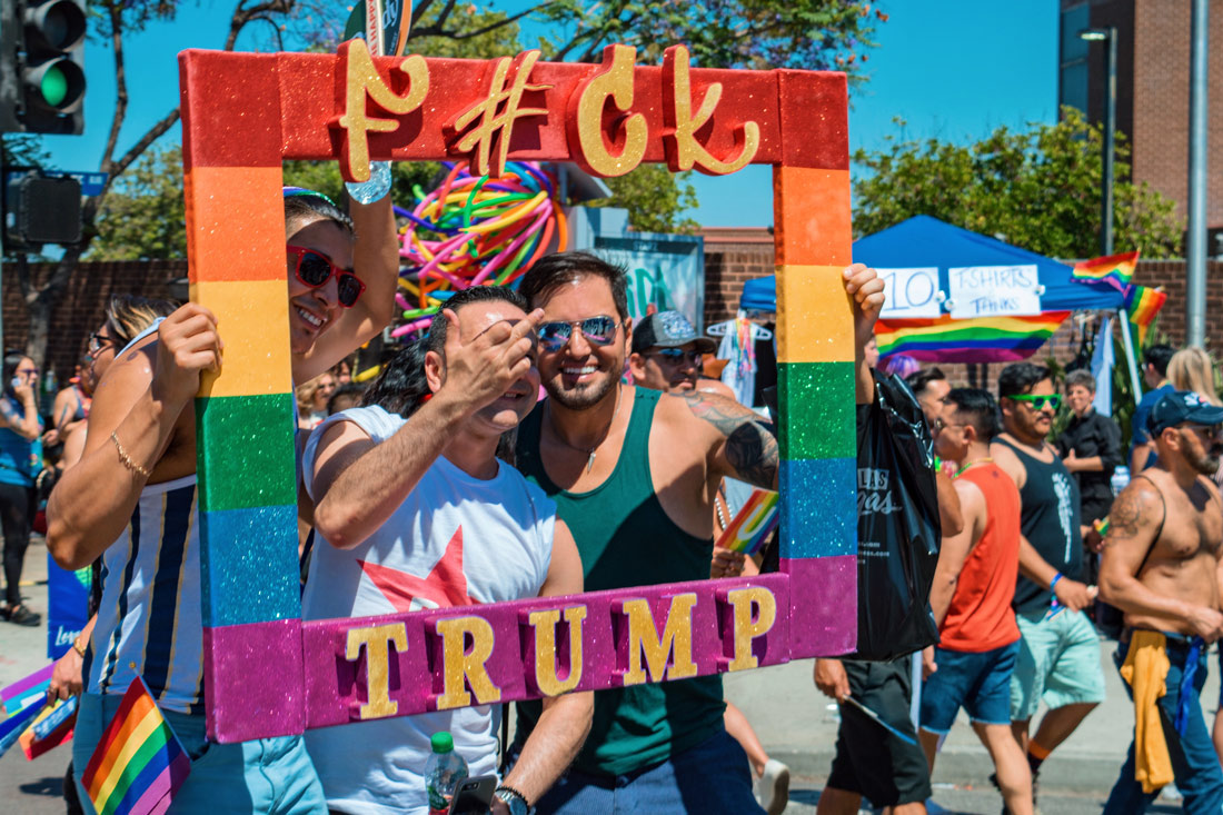 'F#ck TRUMP' sign for some extra gay selfie fun on Santa Monica Boulevard in West Hollywood gay guys taking selfies with rainbow sign Fuck Trump © Coupleofmen.com