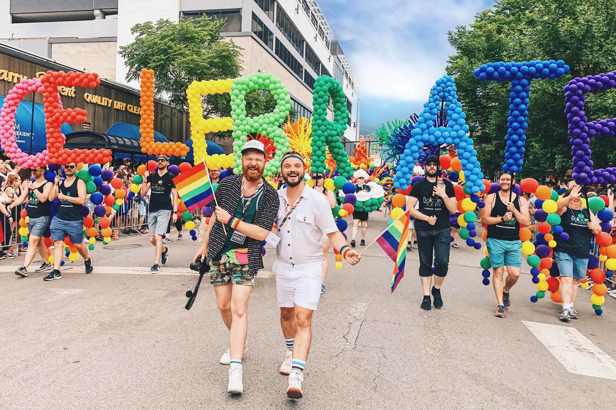 Chicago Gay City Tipps Gay Couple holding hands in front of the Rainbow Balloons Chicago Gay Pride Parade 2019 © Coupleofmen.com