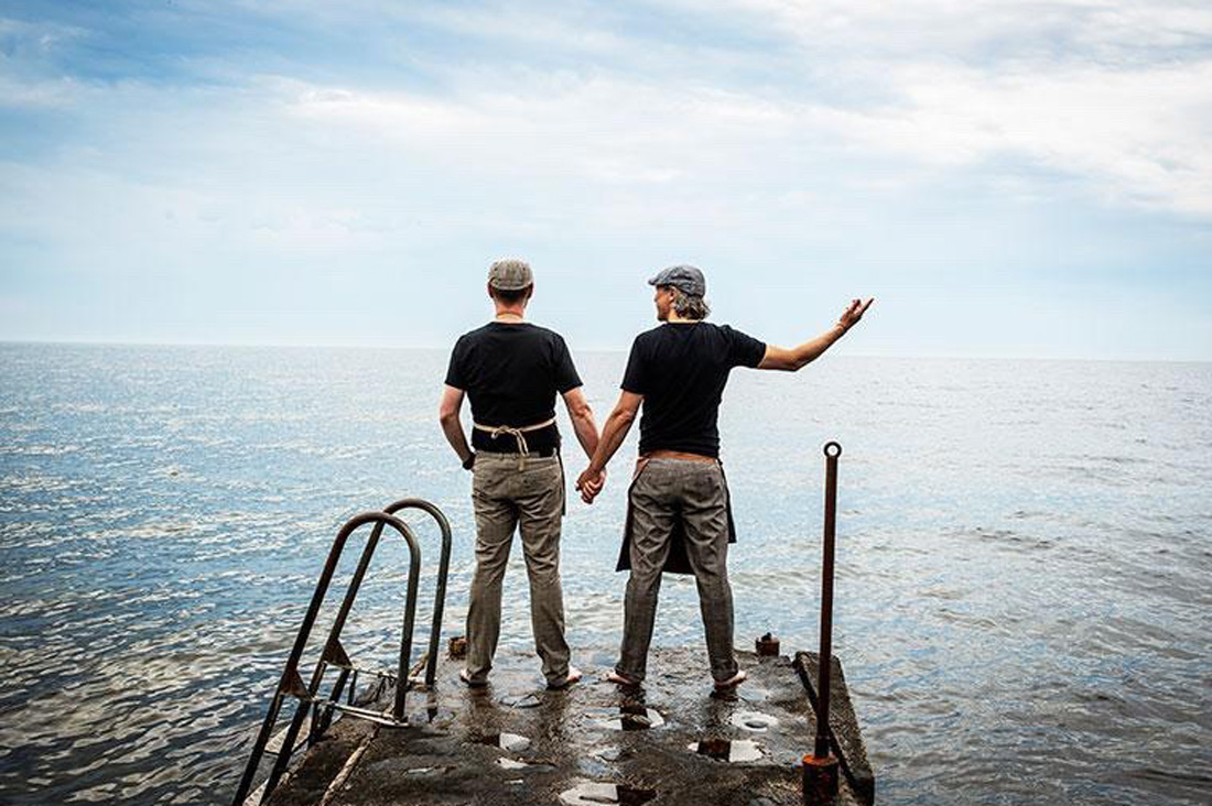 two gay men hand in hand looking over the baltic sea in Sweden Hand in Hand into a great future together - © Café Ransvik Havsveranda