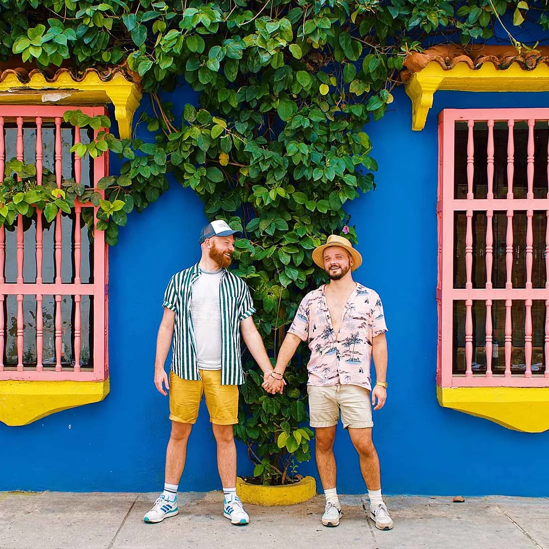 Gay Reise Cartagena Gay Couple hand-in-hand in front of the colorful house facades in Cartagena © Coupleofmen.com