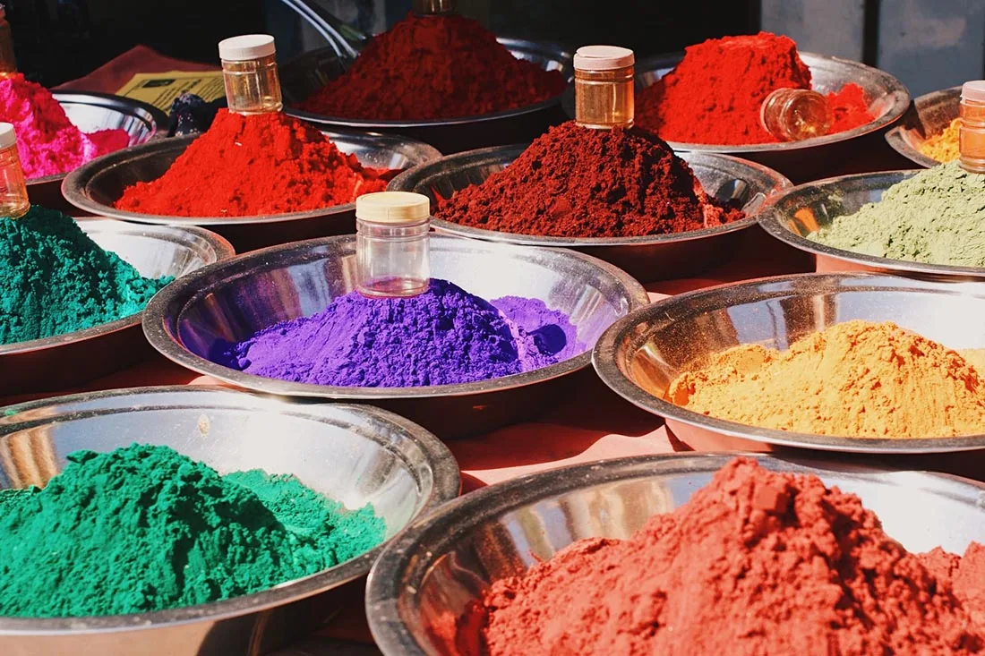 Color powders on a street market on the way to Khajuraho © Coupleofmen.com