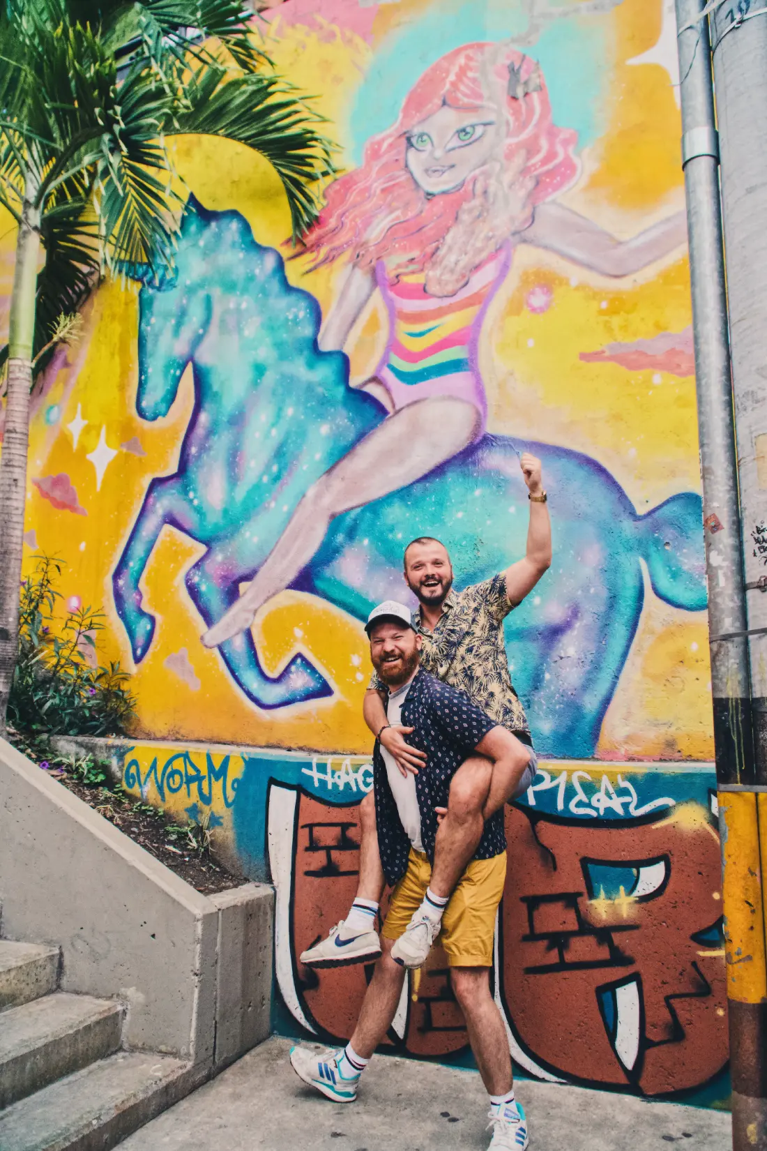 Gay Medellín Riding a unicorn at Selfie with our local tour guide at Medellín‘s Comuna 13 neighborhood © Coupleofmen.com