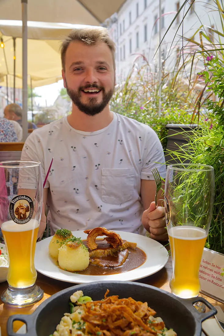 Munich Gay City Trip Karl happily enjoying his lunch with a good beer © Coupleofmen.com