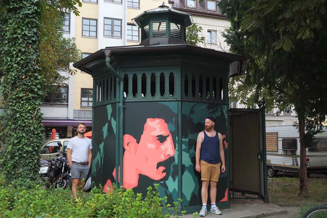 Munich Gay City Trip Playing some cruising scenes at the gay monument The Pissoir in memory of Freddie Mercury, Albert Einstein and Rainer Werder Fassbinder © Coupleofmen.com