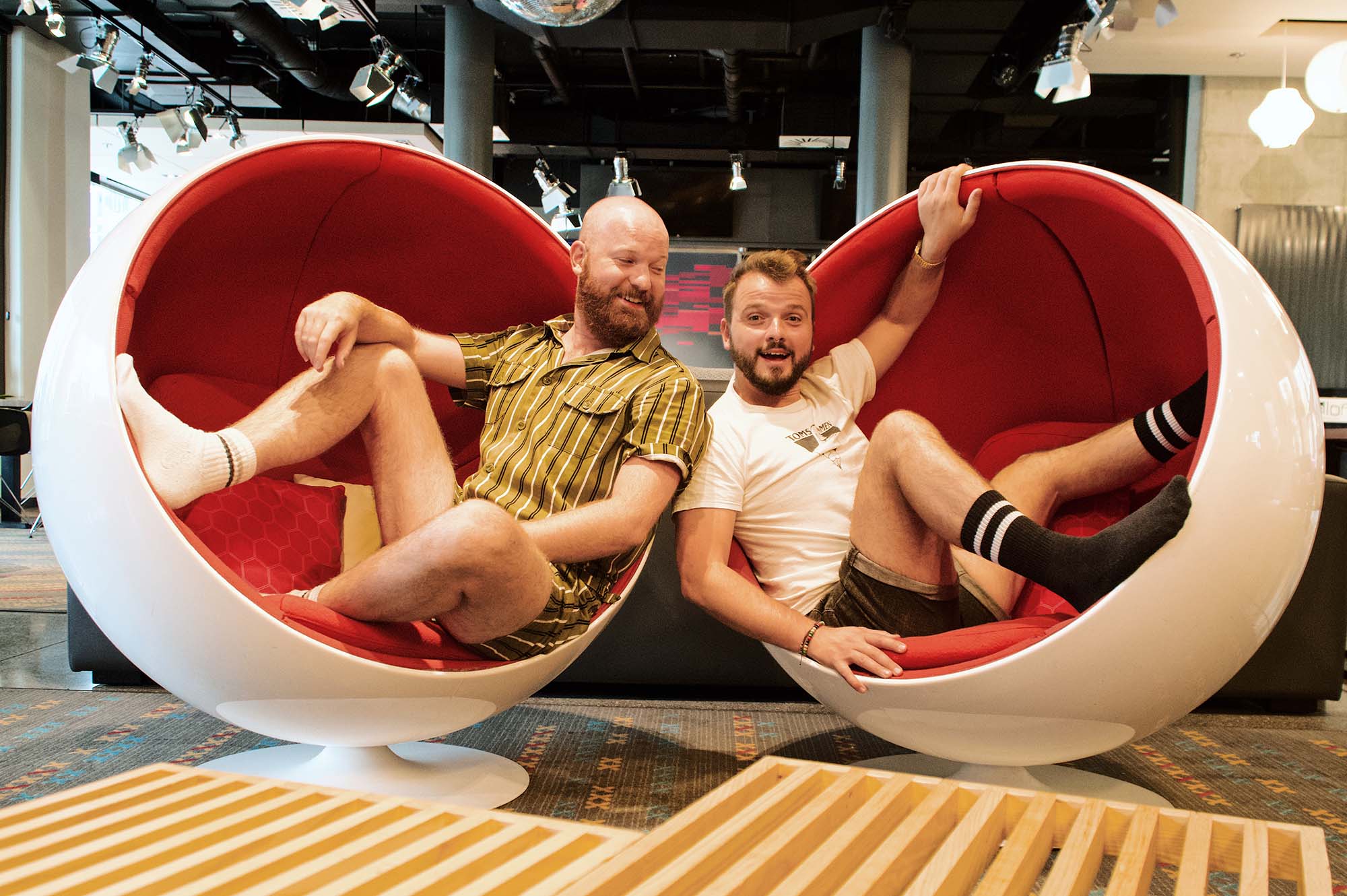 Schwulenfreundliches Hotel Aloft München Gay-friendly Design Hotel Aloft Munich, Germany © Coupleofmen.com Gay Travel Bloggers having fun in vintage white-red chairs in the lobby of the design Hotel in Munich close to Central Station