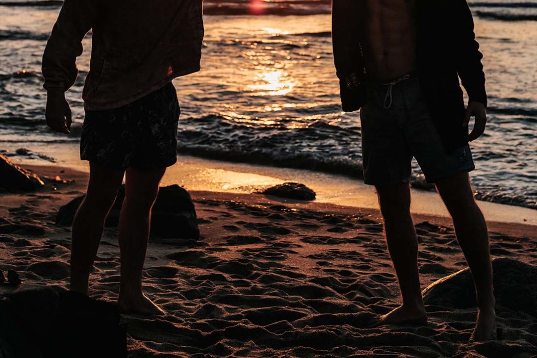 Gay men meeting at the beach around sunset 