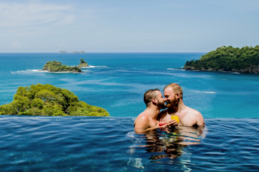 A Gay Couple enjoying vacation in pool with blue water at the ocean front © Coupleofmen.com