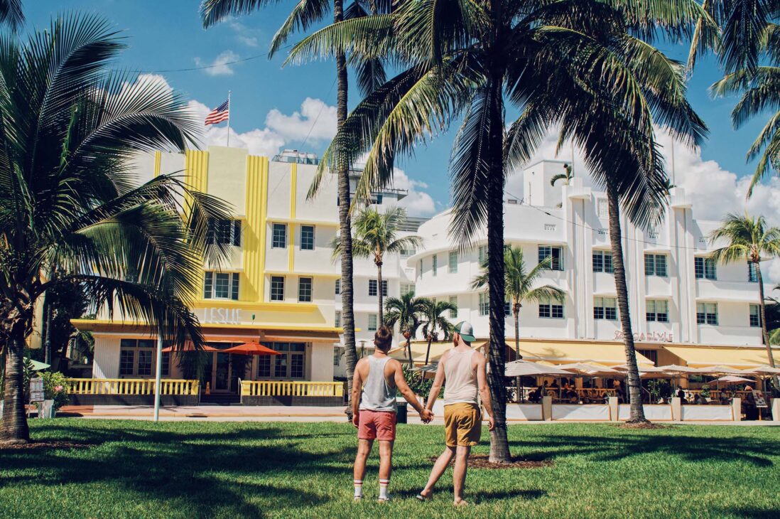 Hand in Hand am South Beach mit Blick über die Art Deko Gebäude © Coupleofmen.com