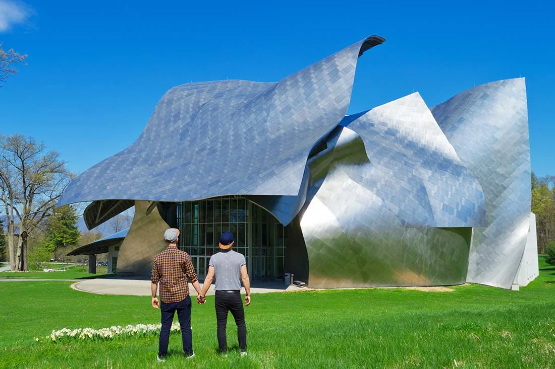 Hand in hand in front of the magnificent and unique architecture designed by Frank Gehry © Coupleofmen.com