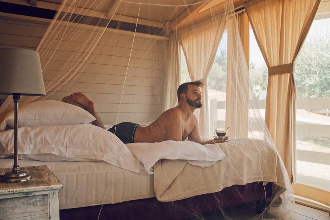 Karl enjoying his morning coffee in bed of our Be Vedetta lodge | Gay-friendly Glamping in Tuscany, Italy © Coupleofmen.com