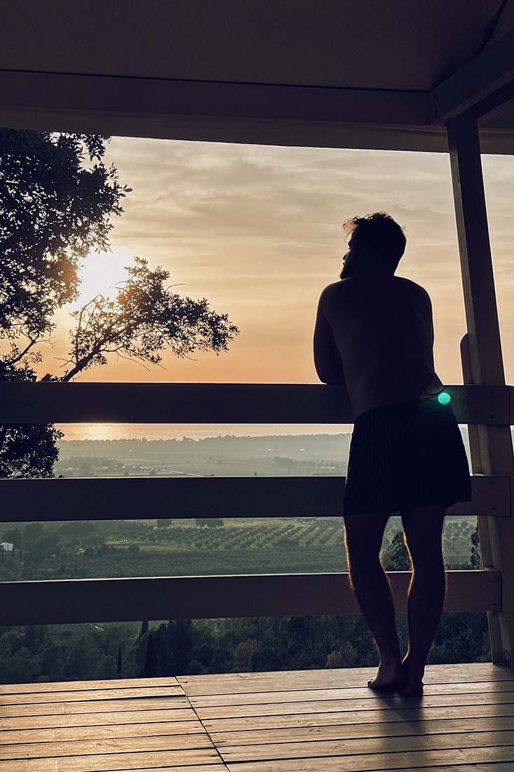 Karl enjoying the sunset view from our veranda of the Be Vedetta lodge | Gay-friendly Glamping in Tuscany, Italy © Coupleofmen.com