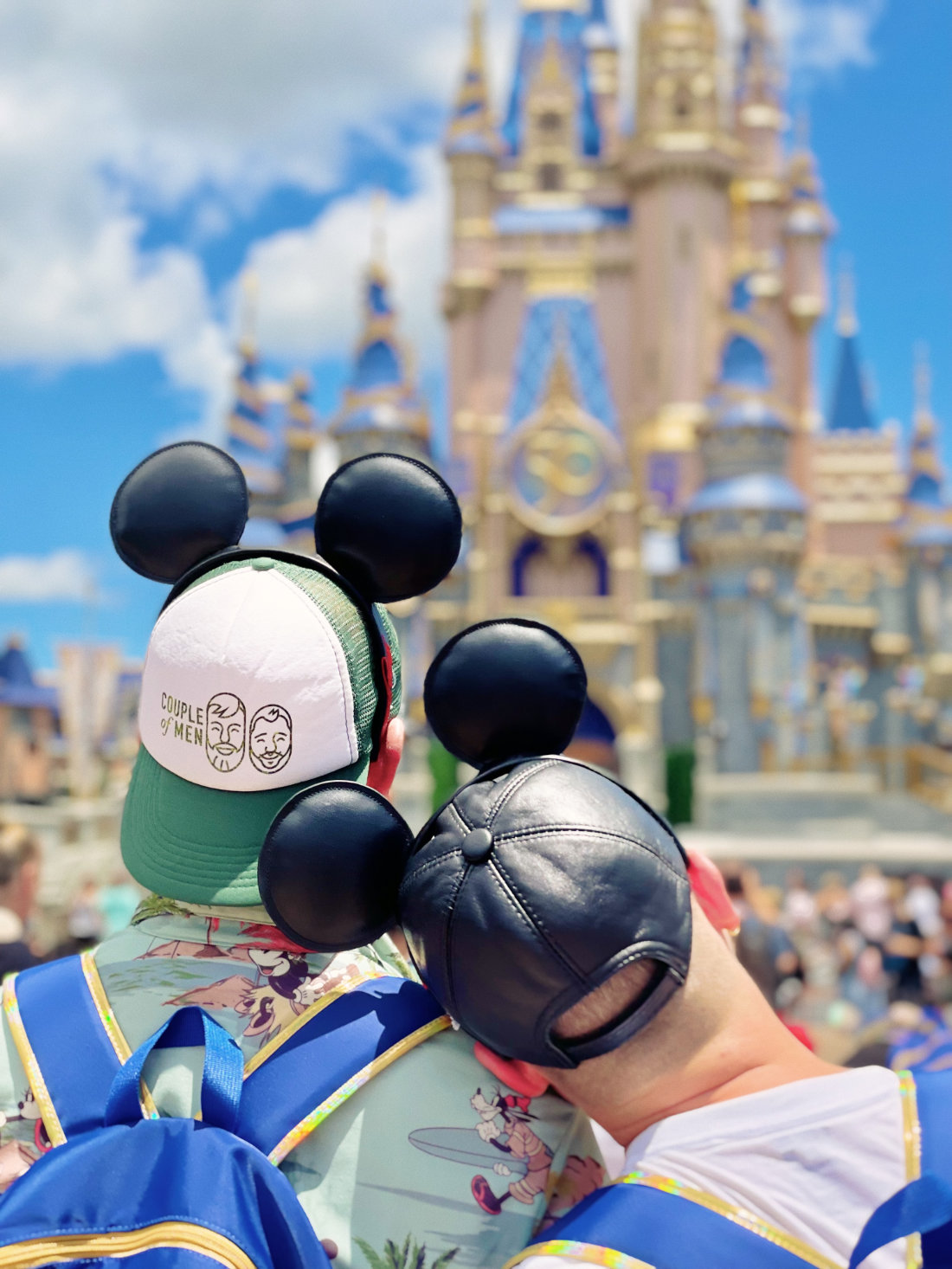 A gay couple of men with leather mickey ears on in front of Cinderella Castle at Walt Disney World Magic Kingdom Park