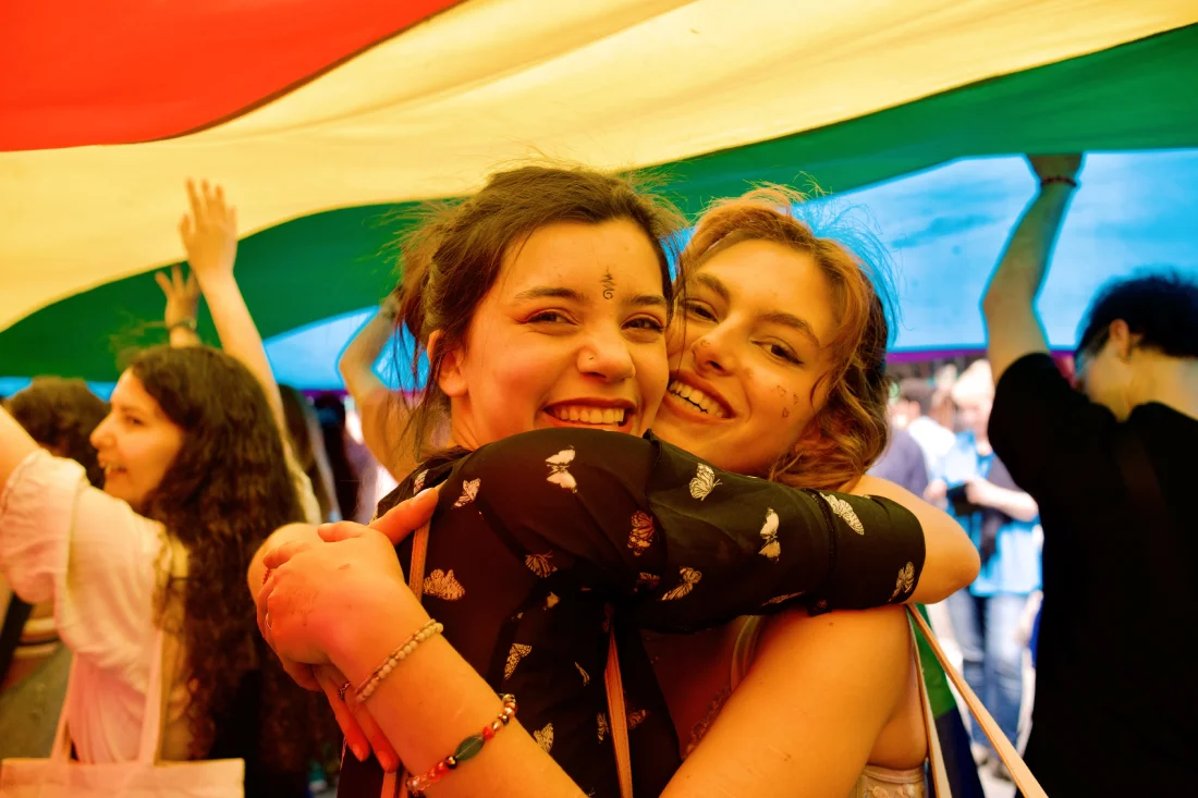 Lesbian love under the huge rainbow flag during Pride in Brussels 2023 © Coupleofmen.com 