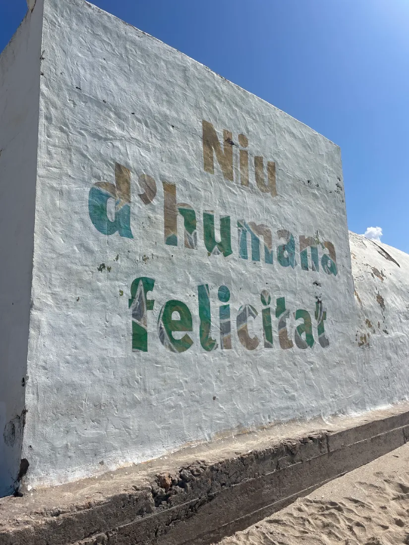 Sign at the beach: “Niu d’humana felicitat” - which fittingly translates to “Nest of Human Happiness” © John Ripploh