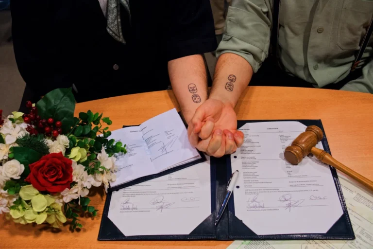 Hand in hand at the Registry Office Amsterdam with signed documents &copy; Coupleofmen.com