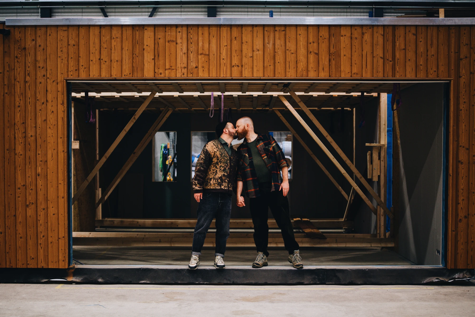 Two gay builders in front of their prefab project in Amsterdam &copy; Coupleofmen.com Roof extension Amsterdam