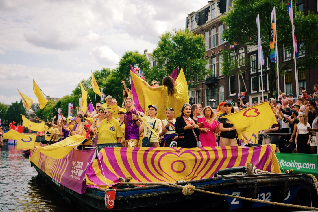 Intersex Boat full of yellow flags with purple hearts and circles &copy;&nbsp;Coupleofmen.com