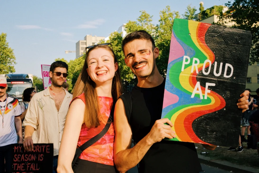 Pride poster: PROUD AF with two cuties holding it