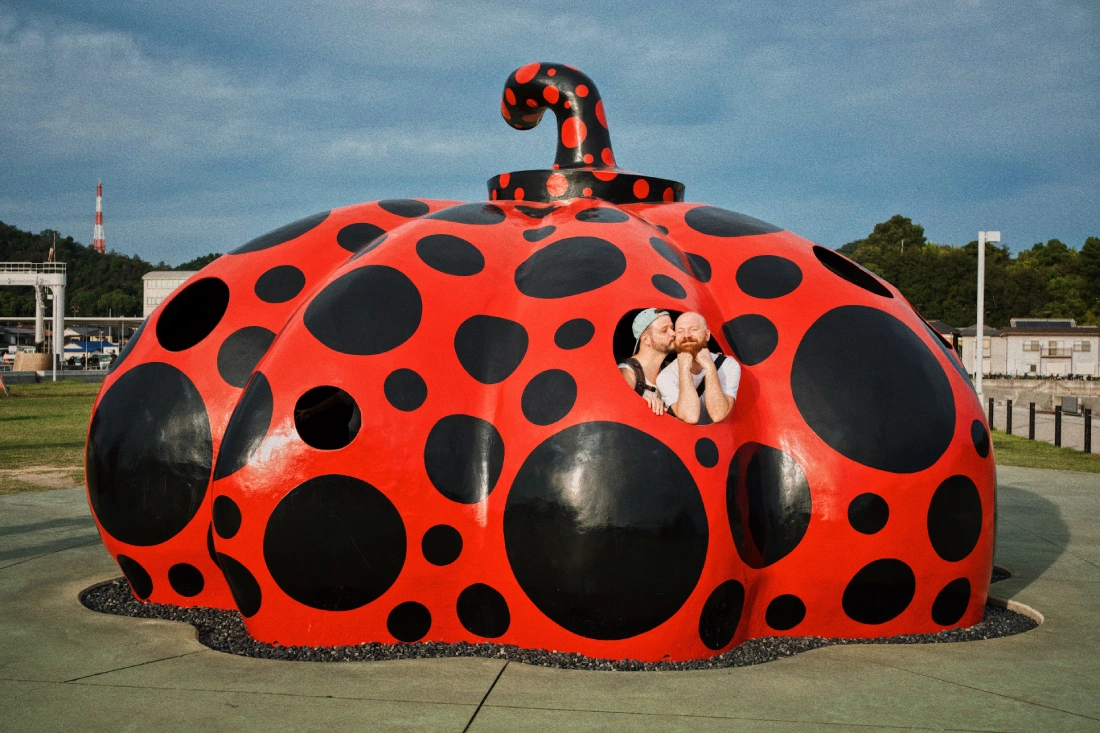 Selfie in the red pumpkin of artist Yayoi Kusama on the Naoshima pier | Naoshima gay travel guide